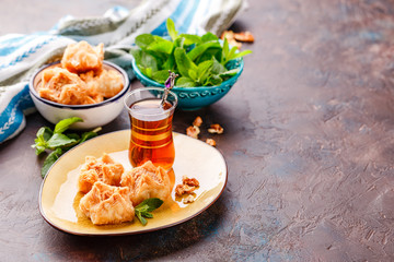 Traditional Turkish arabic dessert and a glass of tea with mint
