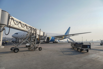 Passenger aircraft at the airport near the terminal. Unloading and loading baggage. Stock photo