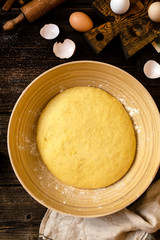 Overhead shot of bamboo bowl with homemade dough on rustic table