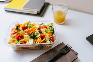 Healthy food in lunch box, on working table with laptop