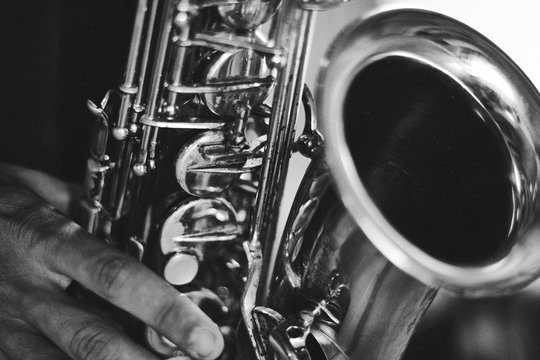 Black and white closeup picture of hands of a man playing saxophone