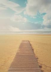 Fototapeta na wymiar vacation background of beach with wooden boardwalk on summer