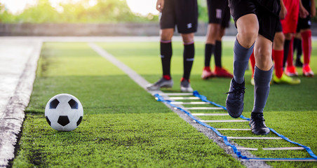 Soccer player Jogging and jump between marker for football training. Ladder Drills Exercises for...