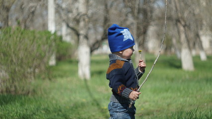 Cute child standing in the park with stick