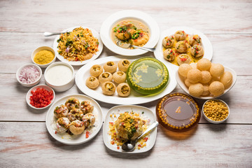 Indian Tea time snacks  in group includes Veg Samosa, Kachori/kachaudi, aloo bonda, khaman dhokla, bread, onion,chilli and moong pakora/pakoda/bhaji/bhajji/Bhajiya/bajji with sauces, selective focus