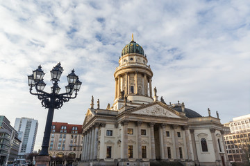 Old streetlight and Neue Kirche (Deutscher Dom, German Church or German Cathedral) in Berlin, Germany, at the Gendarmenmarkt Square in Berlin, Germany, on a sunny morning.