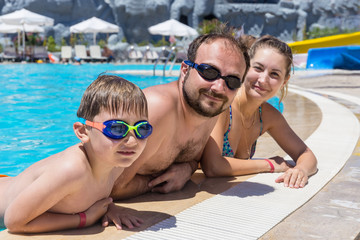 Family swimming in outdoor pool