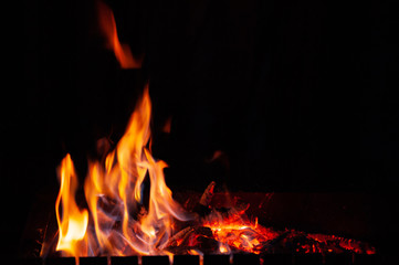 Close-up fire bonfire. The flame of fire burns in an open furnace at night.