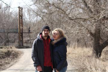 Young lovely couple standing on the road leading to the old bridge
