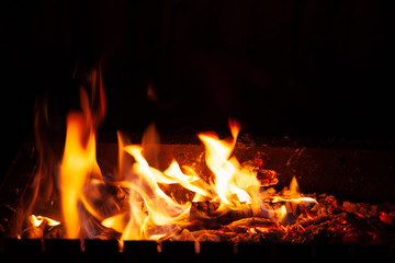 Close-up fire bonfire. The flame of fire burns in an open furnace at night.