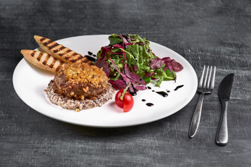 Pozharsky cutlets with vegetables. fried cutlets on a plate on a dark background.
