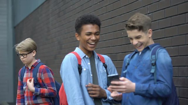 Cruel schoolmates laughing at video about bullied boy, offensive post in network