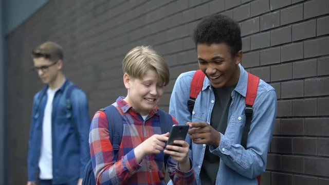 Boys laughing at video about classmate, offensive post in network, cyberbullying