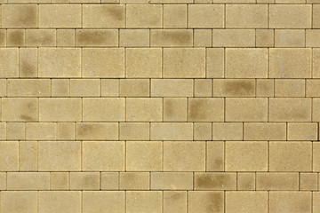 The surface is paved with road tiles of different sizes (multi format). The uneven color of the tile makes it look like a natural stone. View from above.