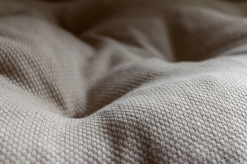 White textile pillow. Wavy textile surface. Seat pad pillow