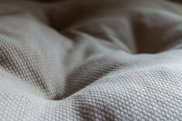 White textile pillow. Wavy textile surface. Seat pad pillow