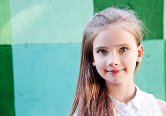 Portrait of adorable smiling little girl child schoolgirl teenager outdoors