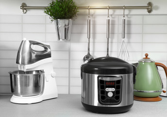 Modern multi cooker and kitchen appliances on table