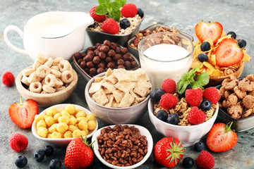 Cereal. Bowls of various cereals, berries and milk for breakfast. Muesli with kids cereals.