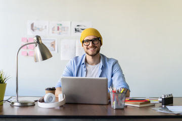 Enjoying his work. Skilled male IT professional freelancer working on clients project, using laptop computer and wireless internet.