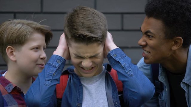 Bullied student covering ears from insults of schoolmates, nervous breakdown