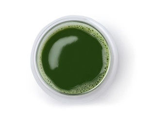 Glass of fresh wheat grass juice on white background, top view