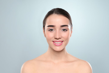 Portrait of young woman with beautiful face against color background