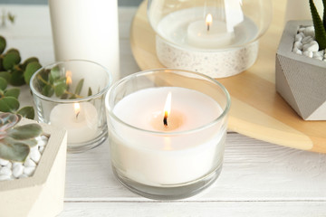 Fototapeta na wymiar Burning aromatic candle and plants on table