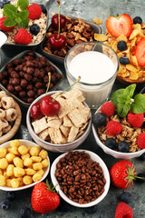 Cereal. Bowls of various cereals, berries and milk for breakfast. Muesli with kids cereals.