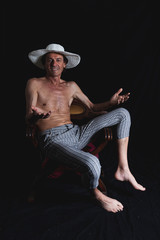 Naklejka premium portrait of mature hipster man sitting in a photo studio
