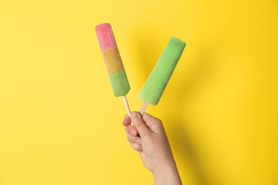 Woman holding delicious ice creams against color background