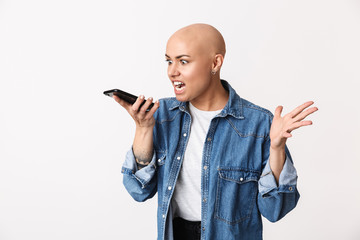 Displeased angry bald woman posing isolated over white wall background talking by mobile phone.