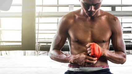 The boxer uses a hand cuff to prevent injury before training.