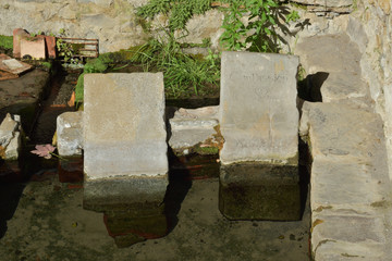 Détail, ici contemplation, des pierres gravées du lavoir à Audaux petit village des Pyrénées...