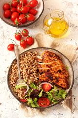Healthy dinner.Grilled chicken and quinoa, mix salad and tomato 