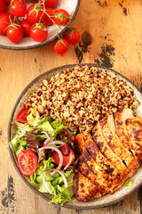 Healthy dinner.Grilled chicken and quinoa, mix salad and tomato 