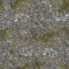 The wall of stone has aged with time and sprouted green moss.Texture or background