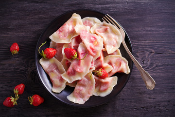 Dumplings, filled with strawberries. Varenyky, vareniki, pierogi, pyrohy. Diet vegetarian food