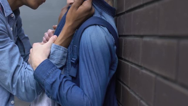 African american teenager bullying weak boy, intimidating with physical abuse