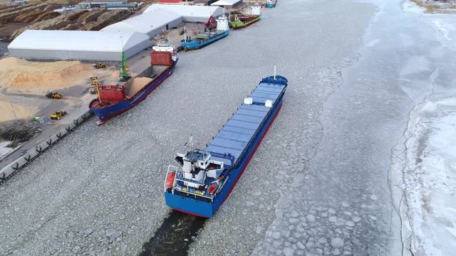 Cargo ship arriving to industrial harbour