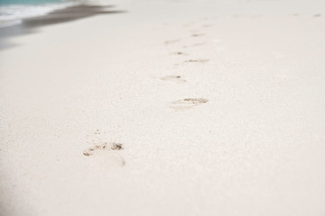 FOOTPRINTS IN THE SAND AT THE BEACH