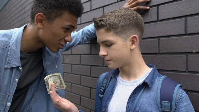 Afro-american guy extorting money from poor boy, dissatisfied with one dollar