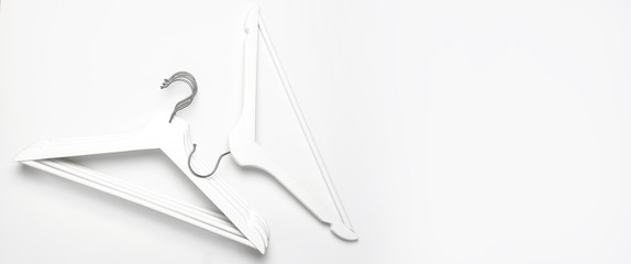 Flat lay top view White wooden hangers on white background copy space minimalism style. Sale discount store shopping concept, design empty hanger. Creative fashion beauty background. Feminine blog