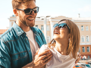 Portrait of smiling beautiful girl and her handsome boyfriend. Woman in casual summer jeans clothes. Happy cheerful family. Female having fun on the street background