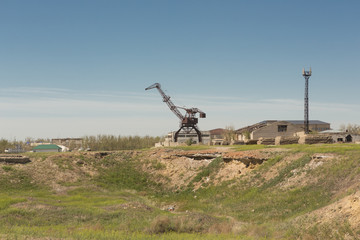 Fototapeta na wymiar Port crane in an abandoned fishing port on the dried Aral sea