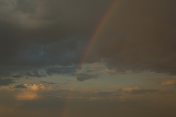 Rainbow in dark rain clouds, after rain