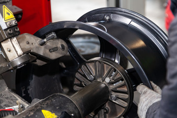 The process of repairing an automobile wheel using a special press on a machine for straightening...