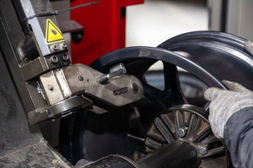 The process of repairing an automobile wheel using a special press on a machine for straightening...