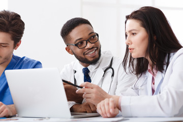 Two Medical Doctors Consulting, Using Laptop In Office