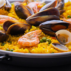 Close up of Seafood Paella with  prawns, clams and mussels on saffron rice with vegetables served...